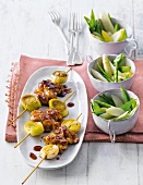 Yakitori skewers with wasabi, asparagus and pea salad on plate