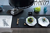 Salad and cutlery on slate table top