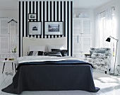 Bedroom in black and white with striped wallpaper