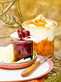 Apricot with ricotta cream, cherry chutney in glass jar and manchego cheese on plate