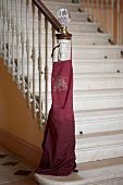 Red apron hanging on cellar railing stair