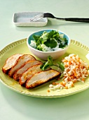 Bowl of coriander yoghurt and Thai chicken on plate