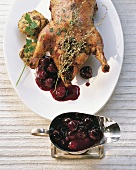 Close-up of roasted duck with sour cherry sauce in serving dish