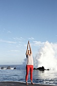 Brunette woman performing sukshma yoga exercise on beach