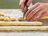 Close-up of hands cutting dough in pieces, step 2