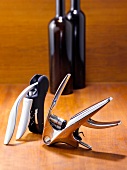 Two levers with corkscrew beside wine bottles