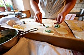 Close-up of woman's hand filling dough for dumplings