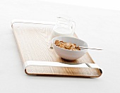 Muesli in bowl on laminated wooden tray
