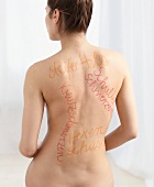Shoulder, back, neck, and lower back pain written with felt pen on nude woman's back