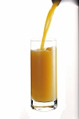 Orangensaft wird in ein Glas eingeschenkt