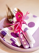 Cutlery wrapped with purple and white napkins