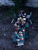 Garden table with flowers, candles and light summer dishes