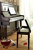 Piano and piano stool with notes on wooden floor