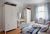 Bedrooms in Scandinavian style with dressing table, wardrobe and bed with cushions