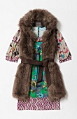 Fur vest with belt over colourful printed dress on white background