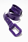 Close-up of purple patent belt on white background