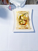 Monkfish medallions in parchment on serving plate