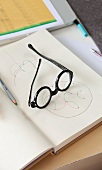 Close-up of black glasses on drawing book
