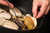 Close-up of zander being stir fried in frying pan