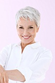 Portrait of happy woman with short gray hair wearing white shirt, smiling