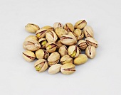 Pistachios in broken shells on white background