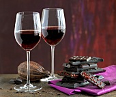 Two glasses of red wine and stack of chocolate