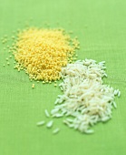 Couscous and basmati rice on green background