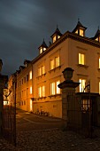 An old town house by night with illuminated windows and gables