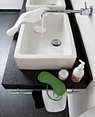 Wash basin with running water from tap, hand wash and napkin, elevated view