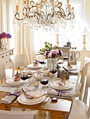 Festively decorated table with champagne glass, plates and chandeliers