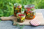 Vegetables in screw cap jars on cutting board