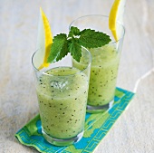 Glass of two smoothie with kiwi and melons