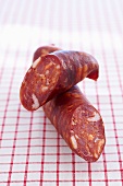 Close-up of Spanish chorizo on red and white checked cloth