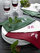Napkins with painted monogram on pile of plate