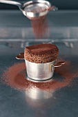 Dusting cocoa powder on chocolate souffle