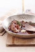 Close-up of calf's liver with raisins in saucepan