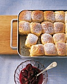 Rohrnudeln in baking tray with plum compote in bowl