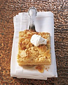Close-up of marzipan crumble cake with cream on tissue