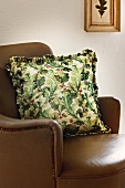 Pillow with oak leaves pattern on brown sofa