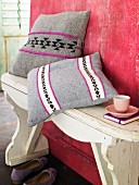 Scatter cushions with embroidered covers on wooden bench