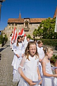 Girls in white tulle dress marching on street in Franconian Switzerland, Bavaria, Germany