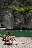 Women wearing swimsuit, sitting on deck near pool, Bavaria, Franconian, Switzerland