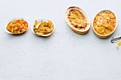 Four different dishes of potatoes in casserole and bowls