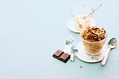 Chocolate cup with hazelnut brittle in glass on white background