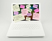 Laptop with sticky notes on white background