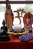 Close-up of lit candle with various god figures