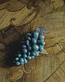 Turquoise grapes as decoration on wooden surface
