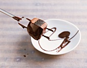 Schokolade, Schichtnougat mit Cassis auf Pralinengabel