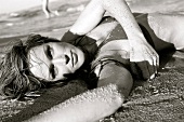 blonde Frau im Bikini liegt im Sand, am Meer, S/W
