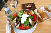 Bowl of salad with various vegetables and drink on table in Stuttgart